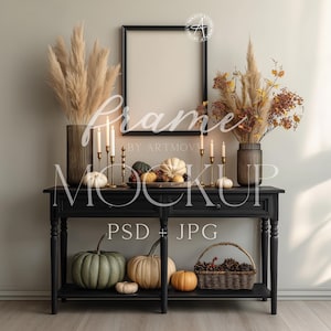 Puede incluir: Una consola negra con un marco de maqueta, calabazas, velas y jarrones decorativos llenos de hierbas y follaje secos. Una cesta de piñas y bayas se encuentra en el estante inferior. La imagen incluye el texto "Frame Mockup PSD + JPG".