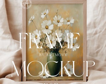 Könnte beinhalten: Ein gerahmtes Gemälde von weißen Blumen in einer grünen Vase. Der Rahmen ist aus Holz und hat eine hellbraune Farbe. Der Text "FRAME BY ARTMOVV MOCKUP PSD" ist auf den Rahmen gedruckt.