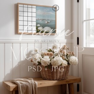 May include: A framed artwork with a grid pattern and a seascape painting hangs above a wooden bench. A wicker basket filled with white and tan flowers sits on the bench, with a folded beige blanket. The words "Frame" and "Mockup" are visible.