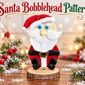 May include: A fused glass Santa bobblehead figure featuring a red hat with white trim, a white beard, blue eyes, and a red suit with a black belt and gold buckle, mounted on a circular wooden base. The text Santa Bobblehead Pattern is visible.
