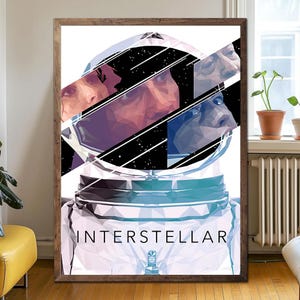 May include: A framed art print with a geometric design of an astronaut's helmet and face, with the word "INTERSTELLAR" at the bottom. The artwork uses blues, purples, and whites against a black starry background. The frame is made of wood.