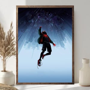 May include: A framed art print featuring a dynamic illustration of a superhero in a black suit, red gloves, and shoes, leaping against a backdrop of a cityscape. The artwork has a modern, comic book style with a blue and black color scheme.