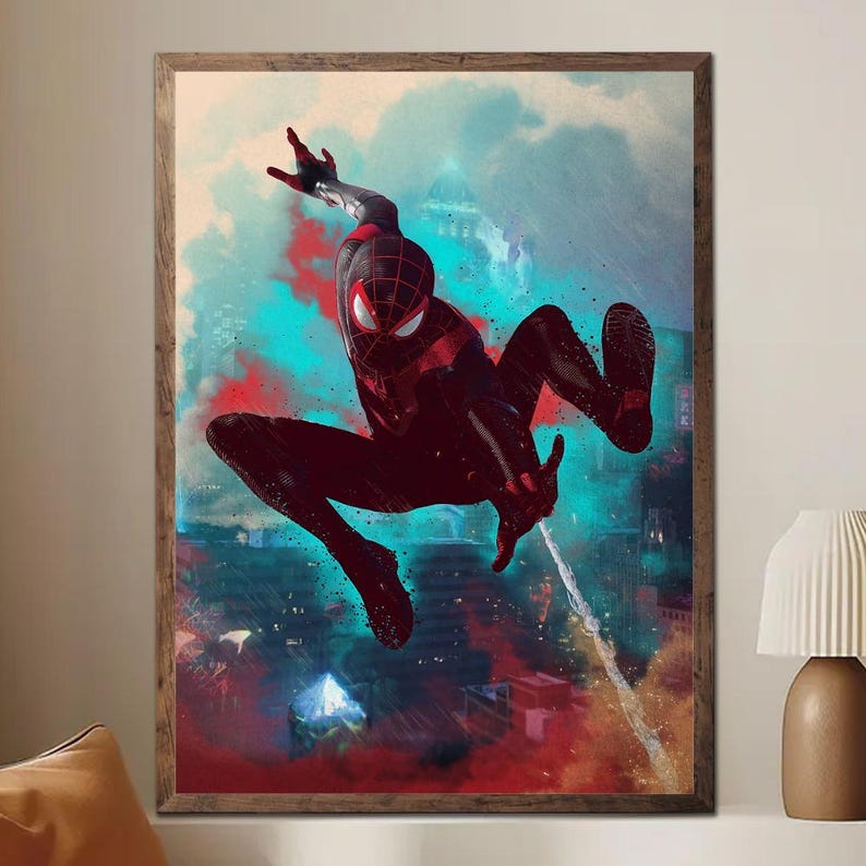 May include: Framed artwork featuring a dynamic illustration of a superhero in a black and red suit, mid-air against a cityscape backdrop. The artwork has a vibrant color palette with red, blue, and teal hues, creating a sense of action and movement. The frame is a warm brown.