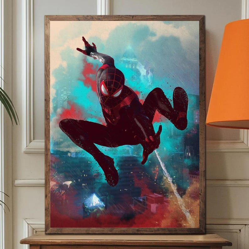 May include: Framed artwork featuring a dynamic illustration of a superhero in a black and red suit, mid-air against a cityscape backdrop. The artwork has a vibrant color palette with red, blue, and orange hues, and is encased in a wooden frame.