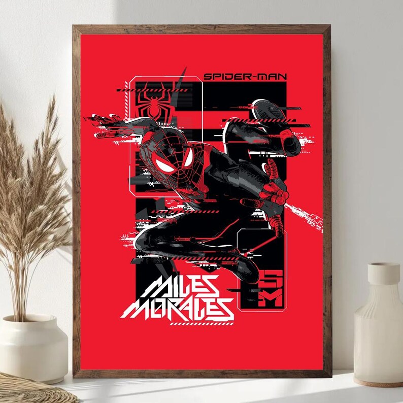 May include: Framed art print of Spider-Man in a dynamic pose against a red background. The artwork includes the text "SPIDER-MAN" and "MILES MORALES" in white, along with graphic elements. The print is in a wooden frame.
