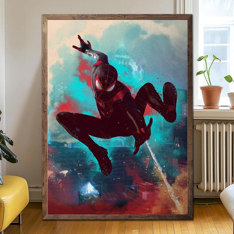May include: Framed artwork featuring a dynamic illustration of a superhero in a black and red suit, mid-air against a cityscape backdrop. The artwork has a vibrant color palette with splashes of red, blue, and teal, creating a sense of action and movement.