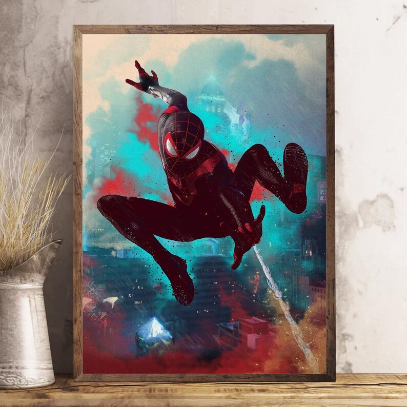 May include: A framed print featuring a dynamic illustration of Spider-Man in a black and red suit, leaping against a backdrop of a city skyline with red and blue hues. The artwork is set in a wooden frame.