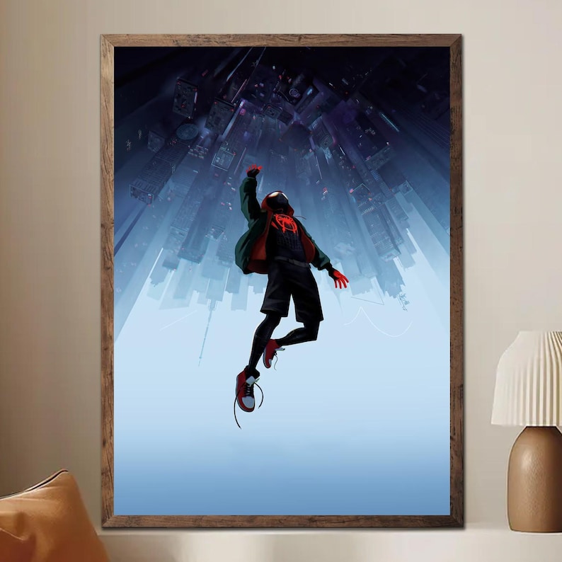 May include: Framed art print featuring a superhero in a black and red suit, mid-air against a backdrop of a cityscape. The artwork has a dynamic perspective, with the city buildings extending upwards. The color palette includes shades of blue, red, and black.