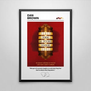 May include: A black framed poster with a red background and a gold-colored cylinder with the text "THE DA VINCI CODE" on it. The poster also includes the author's name, "DAN BROWN", and a quote from the book.