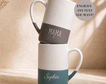 May include: Two tall ceramic mugs stacked vertically. The top mug is white with a dark gray base and the text MAMA with a small heart. The bottom mug is white with a teal base and the text Sophia. A circular badge reads ENGRAVE ANY TEXT YOU WANT!