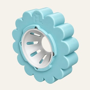 May include: A light blue, flower-shaped plastic object with a white, conical centre insert featuring six elongated slots. The outer edge has a scalloped, petal-like design, and the letters PL are embossed on the top portion of the blue frame.