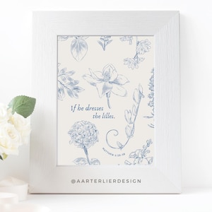 Puede incluir: Una impresión floral azul y blanca con la cita "Si él viste los lirios." y la referencia bíblica "Mateo 6:28-29". La impresión está enmarcada en un marco blanco y tiene el identificador de redes sociales "@aartierlierdesign" en la parte inferior.