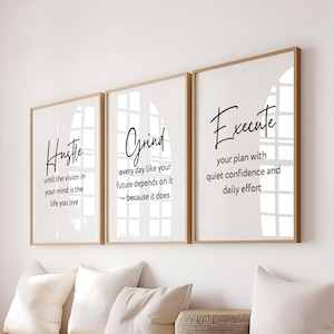 May include: Three rectangular wall art prints in light wood frames featuring black text on white backgrounds. The prints display motivational quotes: Hustle until the vision in your mind is the life you live, Grind every day like your future depends on it – because it does, and Execute your plan with quiet confidence and daily effort.