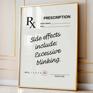 May include: A framed print with a gold border features a prescription design. The text reads "PRESCRIPTION" at the top, followed by lines for client information. Below, it states "Side effects include: Excessive blinking."