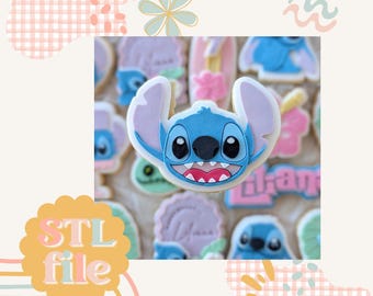 May include: A collection of decorated sugar cookies featuring a blue cartoon character with large ears and a wide smile. The cookies are in various shapes and colors, with the text "STL file" in a yellow and orange circle.