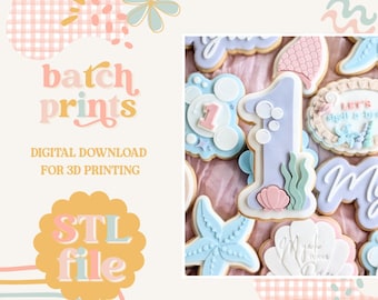 May include: A collection of decorated sugar cookies with a mermaid theme. The cookies feature pastel colors, including blue, pink, and white, and are shaped like a number one, starfish, and seashells. The image also includes the text "batch prints" and "STL file".
