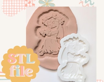 May include: A white silicone mold of a hula dancer with a lei and a flower in her hair. The mold is on a pink silicone sheet.