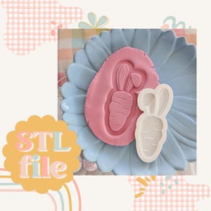 May include: A pink carrot-shaped design pressed into pink clay, next to a white carrot-shaped cookie cutter. The design sits on a blue, flower-shaped plate. The words "STL file" are in a yellow and orange bubble.