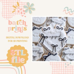 Op de afbeelding: Witte hartvormige koekje versierd met zwarte strikken en het woord "engaged" in zwart schrift. Het koekje is omringd door andere soortgelijke koekjes. De afbeelding bevat ook de tekst "batch prints" en "STL file".