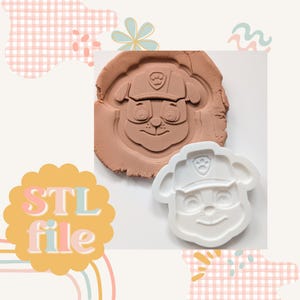 Puede incluir: Cortador de galletas de plástico blanco impreso en 3D de un perro de dibujos animados con un sombrero azul con una huella de pata. El cortador de galletas se muestra presionado en plastilina marrón.