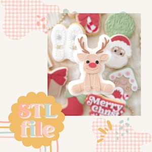 May include: A 3D printed cookie cutter in the shape of a reindeer. The reindeer is sitting with its legs crossed and has a red nose. The cookie cutter is made of white plastic and is ready to be used to create festive cookies.