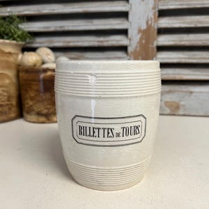 May include: White ceramic jar with black lettering that reads "RILLETTES DE TOURS".