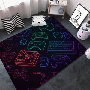 Peut inclure: Un tapis de jeu noir et bleu avec des contours néon de manettes de jeu vidéo, de claviers et de joysticks. Le tapis porte le texte "PRO-ZEN" dans le coin inférieur gauche.