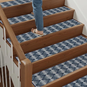 Pode incluir: Um conjunto de degraus de escada com padrão azul e branco com um design geométrico. Os degraus são feitos de um material macio e durável e são projetados para fornecer tração nas escadas.