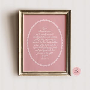 May include: A pink framed print with a white oval containing a bible verse from 1 Peter 3:3-4. The verse reads "Your adornment must not be merely external - braiding the hair, and wearing gold jewelry, or putting on dresses, but let it be the hidden person of the heart, with the imperishable quality of a gentle and quiet spirit, which is precious in the sight of God."