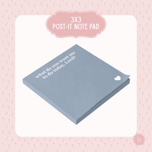May include: A 3x3 inch Post-it note pad in a soft blue hue. The pad features the text "what do you want me to do today, Lord?" in white, with a small heart detail. The design is set against a pink floral background.