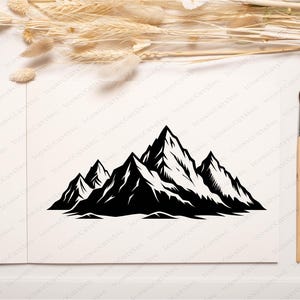 May include: Black and white mountain range illustration. The image features a stylized depiction of several mountain peaks with sharp, jagged edges. The design is set against a neutral background, with a paintbrush and watercolor paints in the corner.