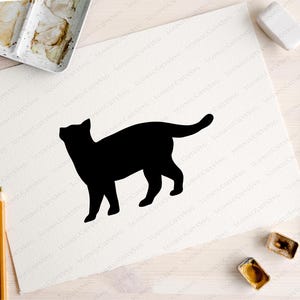 May include: A black silhouette of a cat standing on a white background.