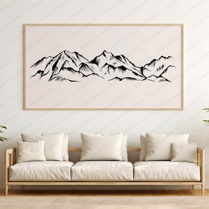 May include: A framed black and white mountain range art print. The artwork features a detailed illustration of a mountain landscape. The print is displayed above a light-colored sofa with cream-colored pillows, creating a minimalist aesthetic.