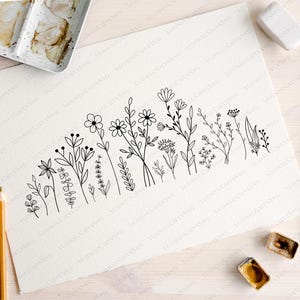 May include: A black and white line drawing of a row of various flowers and plants on a white background.
