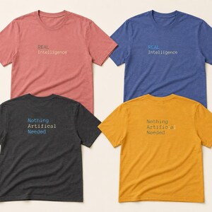 May include: Four short-sleeve crew neck t-shirts in red, blue, dark gray, and yellow. The red and blue shirts feature the text "REAL Intelligence" in the center. The dark gray and yellow shirts feature the text "Nothing Artificial Needed" in the center.