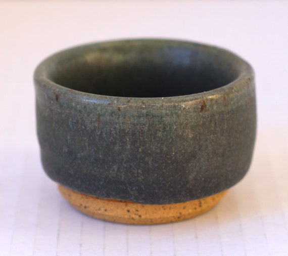 A hand-thrown pottery piece that doubles as tealight holder AND trinket dish — earthy, functional, and visually interesting in those moody dark purple/green glazes.