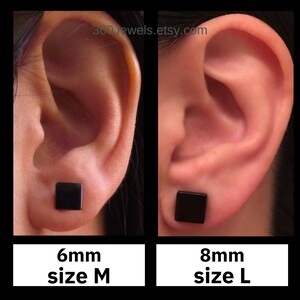 Puede incluir: Primer plano de dos orejas, cada una con un pendiente cuadrado negro. Un pendiente es de 6 mm, talla M, y el otro de 8 mm, talla L. Se ve el nombre de la tienda Etsy, 360Jewels.etsy.com.