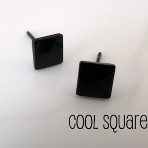 May include: A pair of black square stud earrings. The earrings are made of metal and have a simple, modern design.