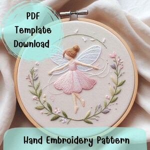 Könnte beinhalten: Ein Stickmuster für Handarbeiten mit einer Fee mit rosa Flügeln und einem rosa Kleid, umgeben von grünen Blättern und Blumen. Das Muster ist in einem Reifen und der Text "PDF Template Download" befindet sich oben links.