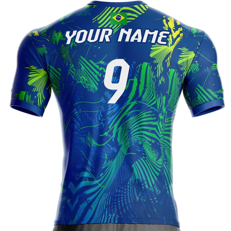 K&ouml;nnte beinhalten: Blaues Sporttrikot mit tropischem Bl&auml;ttermuster in Gr&uuml;n und Blau. Auf der R&uuml;ckseite befinden sich die wei&szlig;e Nummer 9, der wei&szlig;e Text "YOUR NAME" und eine brasilianische Flagge. Das Trikot hat kurze &Auml;rmel und einen Rundhalsausschnitt.