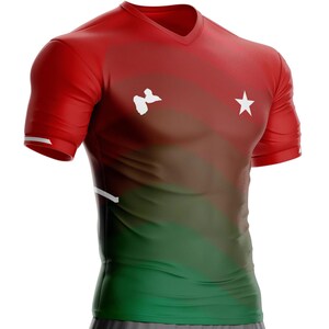 Puede incluir: Camiseta deportiva roja, verde y marrón con cuello en V, con una estrella blanca y una forma blanca en la parte delantera. La camiseta tiene mangas cortas con rayas blancas en los puños. Fabricada con material transpirable.