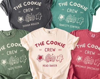 May include: Five crew neck t-shirts in various colors, each featuring the text "THE COOKIE CREW EST. 2025" with a cookie-themed graphic. The shirts have different job titles: Dough Roller, Quality Control, Taste Tester, Head Baker, and Sprinkle Specialist.