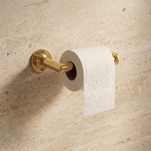 Könnte beinhalten: Ein wandmontierter Toilettenpapierhalter mit gebürstetem Gold-Finish und einer runden Basisplatte, die mit zwei sichtbaren Schrauben befestigt ist. Eine Rolle weißes Toilettenpapier mit geprägtem Wirbelmuster hängt am horizontalen Arm.
