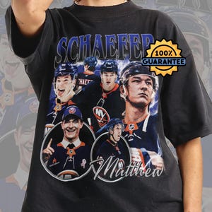 May include: Black t-shirt with a collage of hockey players, the name "SCHAEFFER" in blue, and "Matthew" in white script. A gold "100% GUARANTEE" seal is also visible.