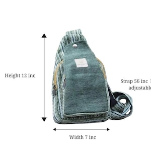 May include: A teal and green sling bag with a zippered front pocket. The bag is 12 inches high, 7 inches wide, and has an adjustable 56-inch strap. The bag has a button closure and a small label.