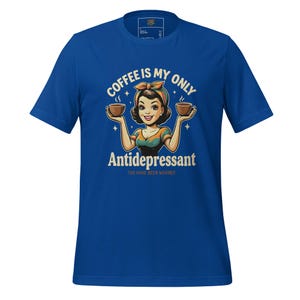 Könnte beinhalten: Königsblaues T-Shirt mit einer Retro-Illustration einer Frau, die zwei Kaffeetassen hält. Der Text auf dem Shirt lautet: "Kaffee ist mein einziges Antidepressivum. Sie wurden gewarnt."