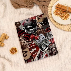 May include: A rectangular tablet case featuring a collage of red, black, and white imagery. Visible elements include a pair of lips with teeth, a leopard print pattern, two cherries, an eight ball, a Nirvana record, and a container of wired earbuds.