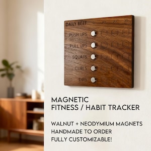 May include: A wooden fitness tracker with the words "Daily Beef", "Push Ups", "Pull Ups", "Squats", "Curls", and "Dips" engraved on it. The tracker has magnetic markers and the text "Magnetic Fitness / Habit Tracker".