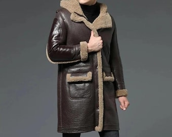 May include: A dark brown leather coat with a hood and tan shearling lining. The coat features two front pockets and shearling trim along the collar, cuffs, and front closure. The coat is knee-length.