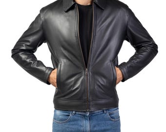 Può includere: Una giacca di pelle nera con chiusura a zip e due tasche. La giacca ha un colletto ed è indossata da una persona con le mani in tasca.